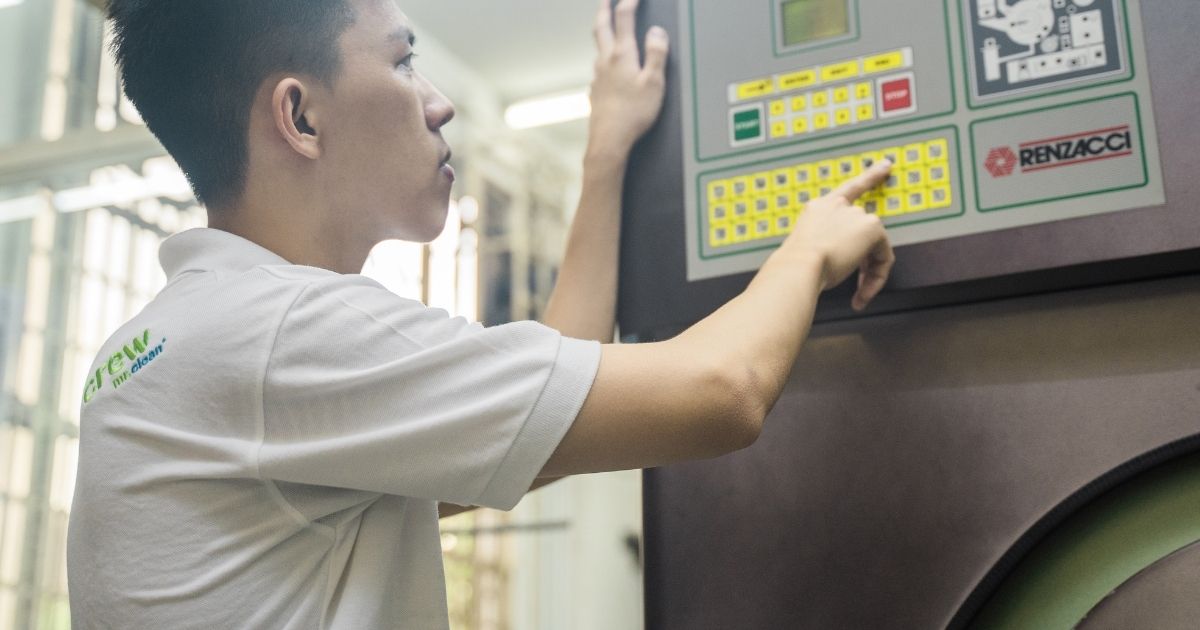 kakitangan mengendalikan mesin cucian kering