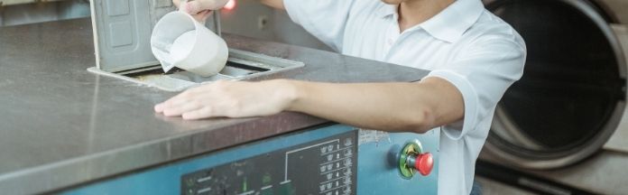 memasukkan serbuk pencuci ke dalam mesin basuh