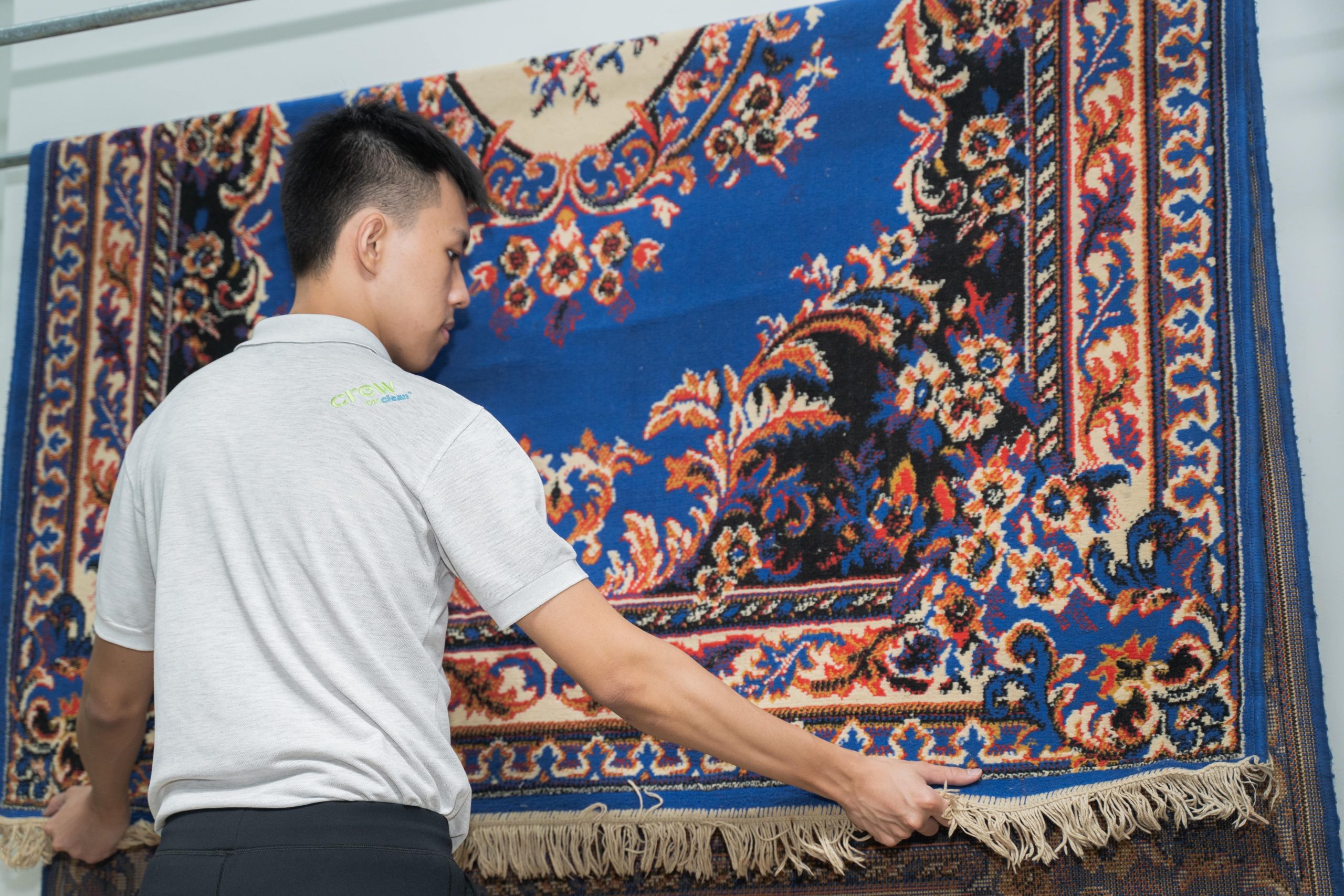 kakitangan sedang mengeringkan karpet di atas rak