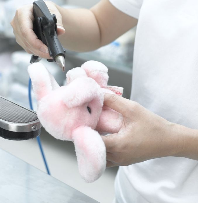 pre-stain removing staff is applying pre-stain removal treatment on toy