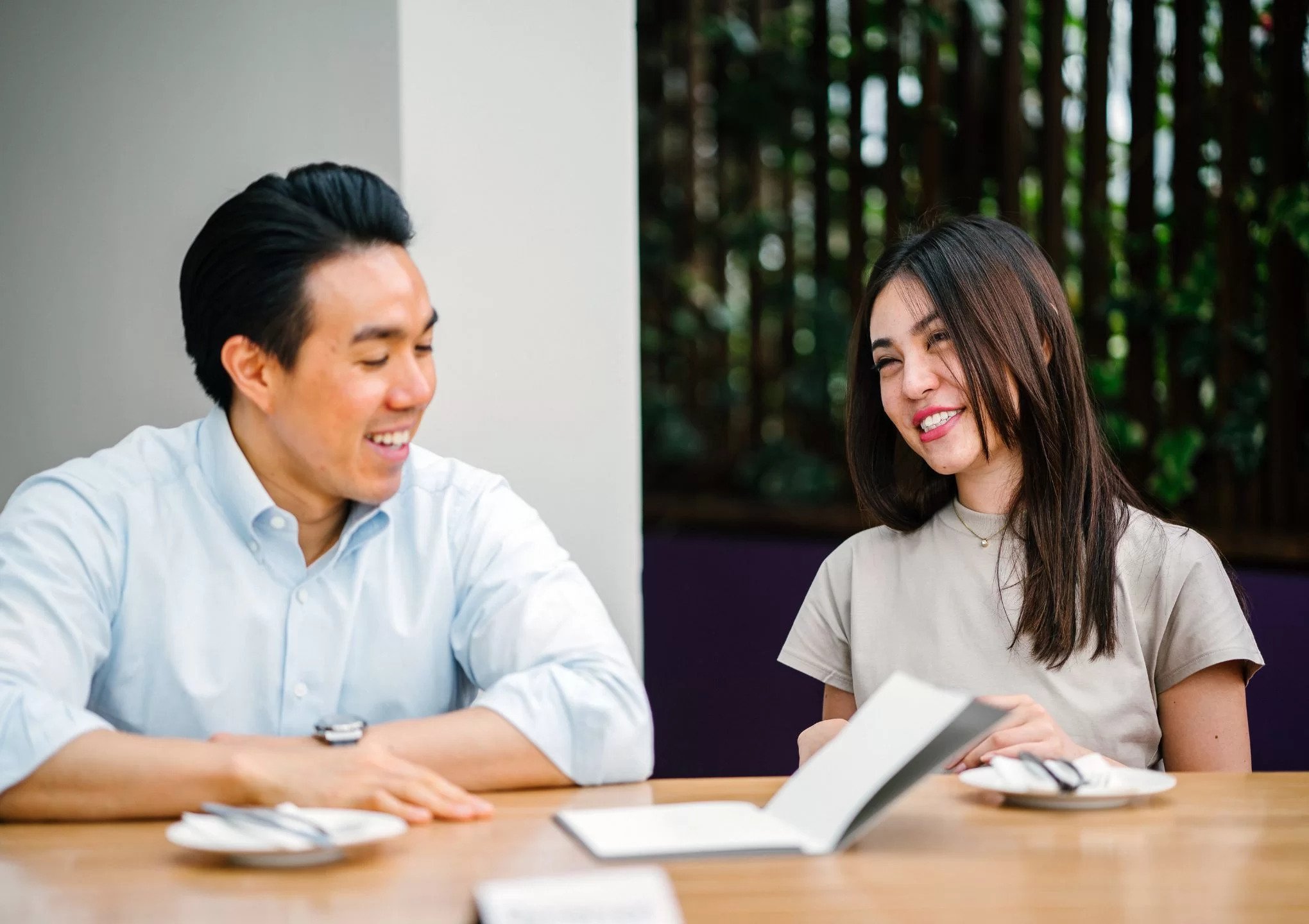 a man and a woman are discussing on the table - post featured image
