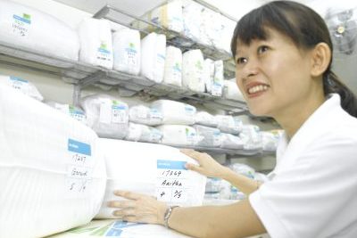 Puan Pamela tersenyum sambil memegang pakaian yang dilipat di dalam beg plastik.