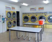 gambar dalaman kedai dobi layan diri dengan mesin kuning - Post Featured Image