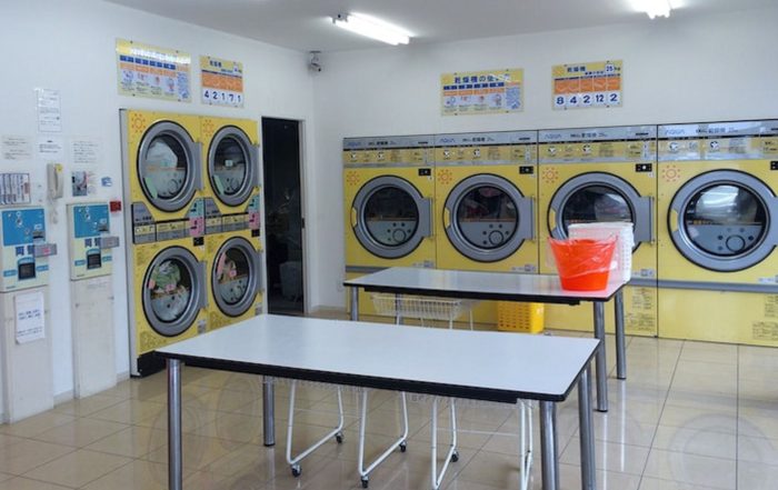 gambar dalaman kedai dobi layan diri dengan mesin kuning - Post Featured Image