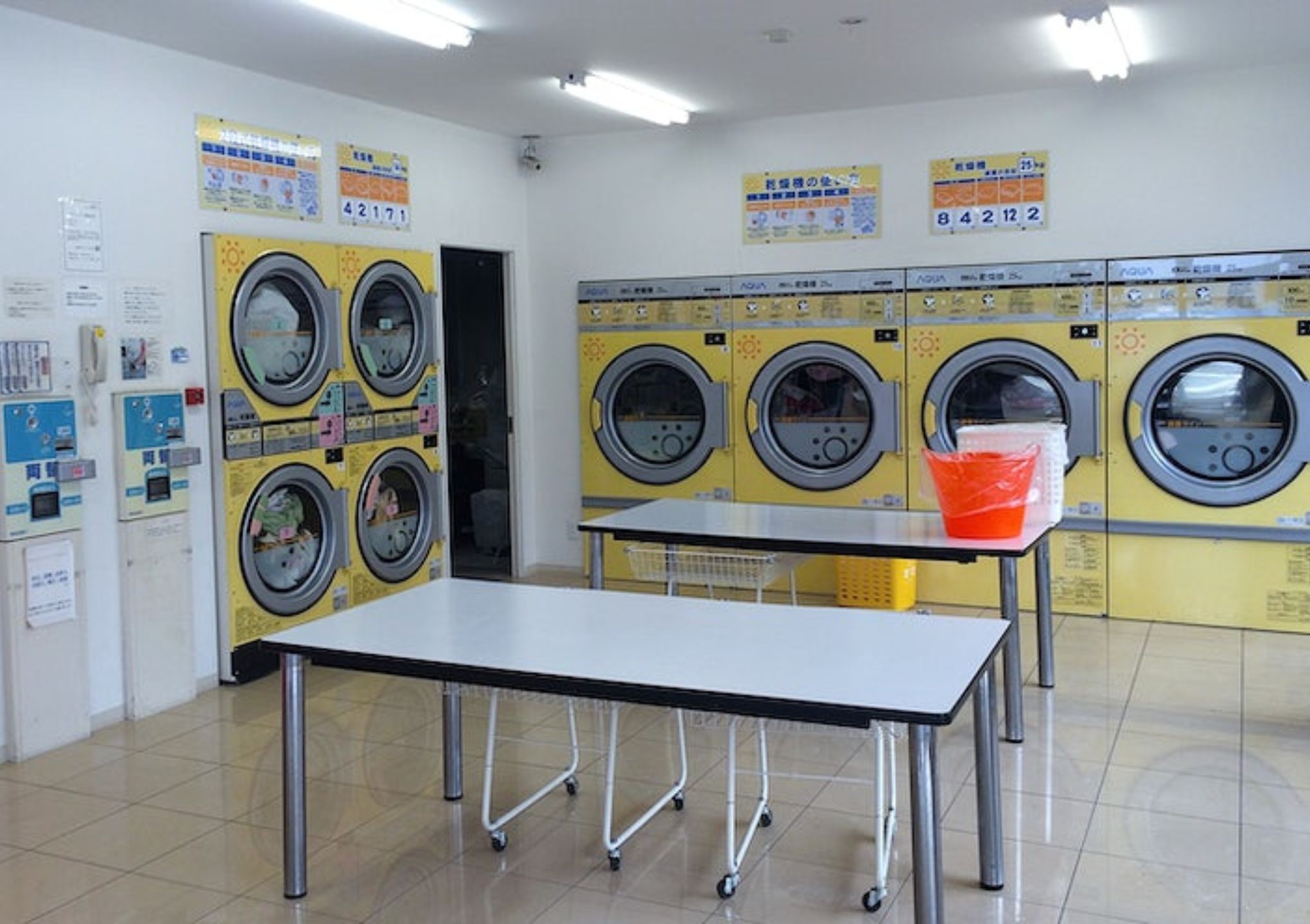 gambar dalaman kedai dobi layan diri dengan mesin kuning - Post Featured Image