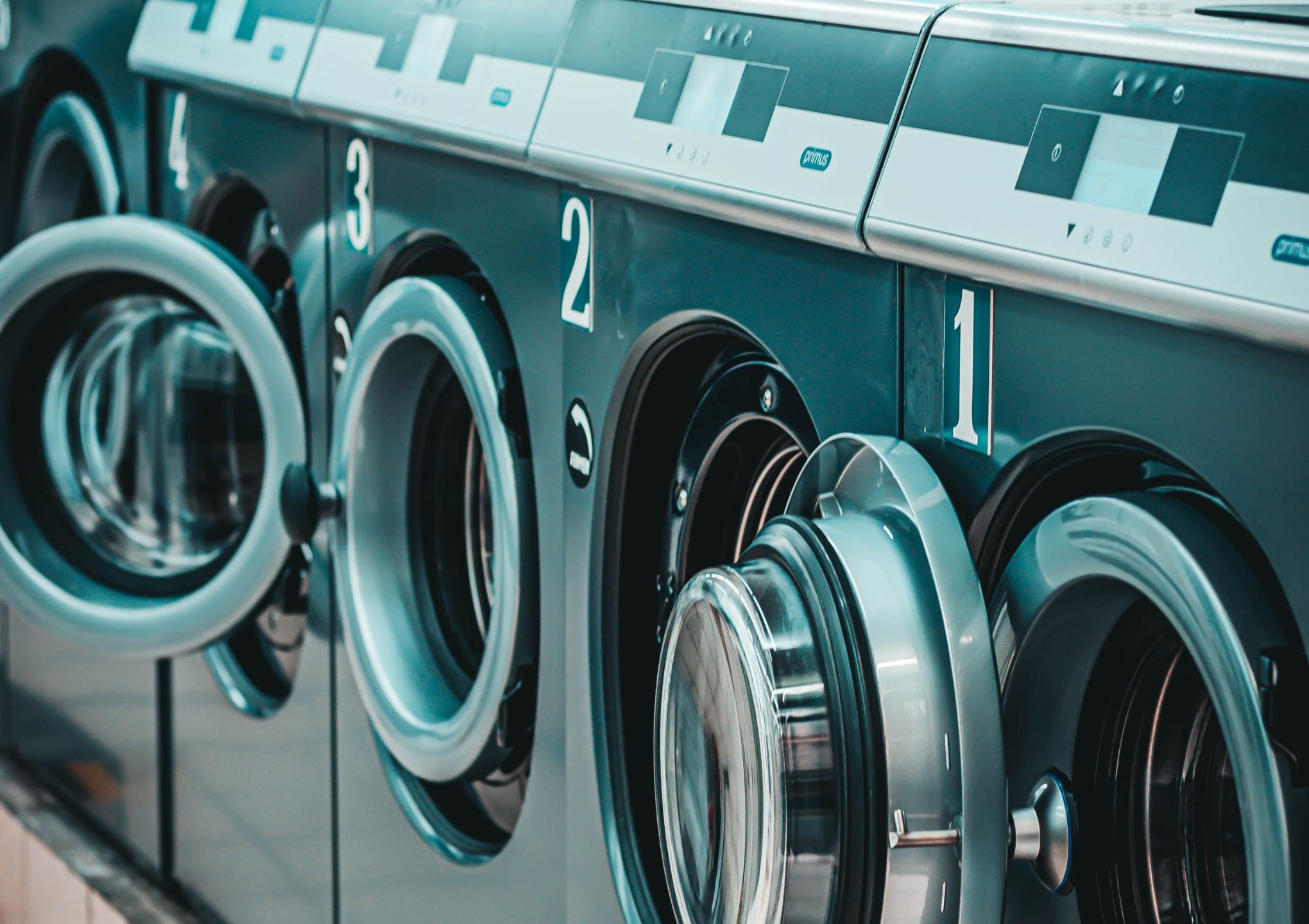 a row of coin laundry machines - Post Featured Image